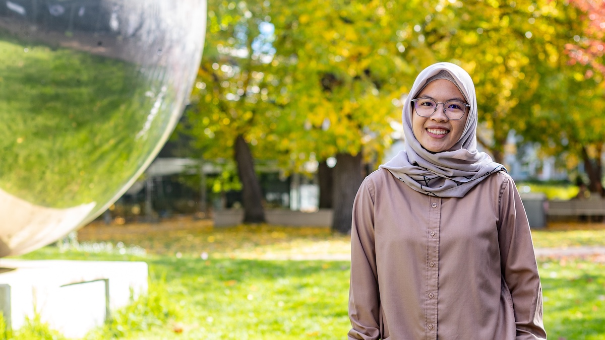 Haasyyati stands next to a sculpture on the ANU Campus. 